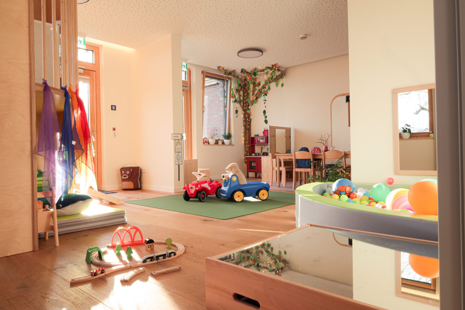 Die Kindergroßtagespflege "Energiebündel" ist mit großen Fenstern und vielen, farbenfrohen Spiemöglichkeiten ausgestattet. Es wurde viel Holz verbaut.